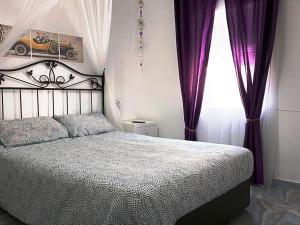 een slaapkamer met een bed en een raam met paarse gordijnen bij casa familiar in San Fernando