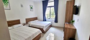 a bedroom with two beds and a window at Sunn Hotel in Vung Tau