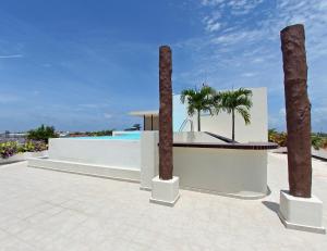 ein weißes Gebäude mit zwei Palmen und einem Pool in der Unterkunft Angelo's Hotel in Playa del Carmen