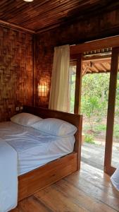 - une chambre avec un lit dans une cabane en bois dans l'établissement Dewandaru Villa Bali, à Angsri