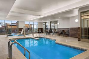 Fairfield by Marriott Inn & Suites Baraboo في بارابو: مسبح في لوبي الفندق مع منطقة لتناول الطعام