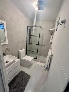 La salle de bains blanche est pourvue de toilettes et d'un lavabo. dans l'établissement Crash Boat 1, à Matias