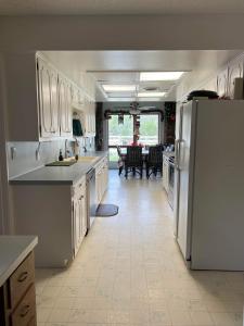 a kitchen with white cabinets and a white refrigerator at Fishers Of Men Ranch Home in Marble Falls