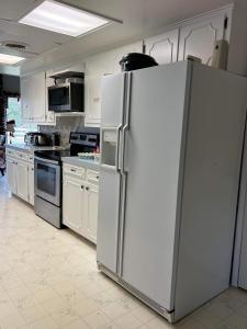 a kitchen with a large white refrigerator in it at Fishers Of Men Ranch Home in Marble Falls +37 photos