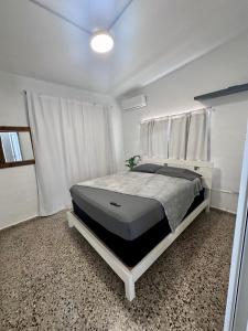 1 dormitorio con 1 cama grande en una habitación blanca en Crash Boat 1 en Matias