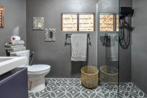 ein Badezimmer mit Toilette und Glasdusche in der Unterkunft Mammaloe in Oranjestad