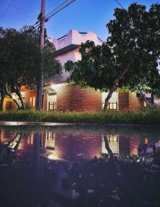 a brick building with a reflection in a body of water at Con SEÑA previa, Alquiler de Sábado a Sábado, Fanuchito Dto PB Esquina, in San Clemente del Tuyú