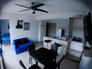 a living room with a blue couch and a ceiling fan at Apartasol de Lujo Santa Fe de Antioquia" in Santa Fe de Antioquia