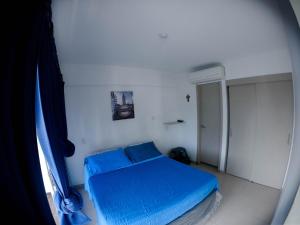 a small bedroom with a blue bed in a room at Apartasol de Lujo Santa Fe de Antioquia" in Santa Fe de Antioquia