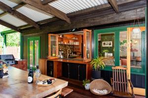 a dining room with a table and a kitchen at Bali Escape, tropical gardens, close to 3 beaches! in Bowentown