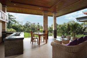 a patio with a table and chairs on a balcony at Dewi Sri Private Villa in Ubud
