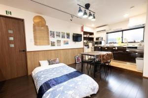 una camera con letto e tavolo e una cucina di 恐竜博物館まで車で5分 自然体験 古来農業体験ができる一棟貸し宿Dinosaur Agri a Katsuyama