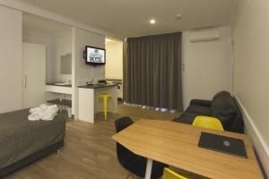 a living room with a couch and a table in a room at Glenmore Palms Motel in Rockhampton