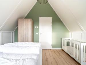 um quarto com uma cama branca e paredes verdes em Modern holiday home in Scherpenisse with garden em Scherpenisse