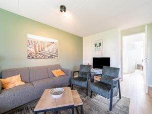 ScherpenisseにあるZeeland Getaway Near Beachのソファと椅子のあるリビングルーム