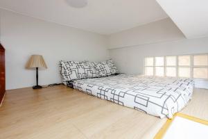 Dormitorio blanco con cama y lámpara en Lovely Loft Apartment in Kalibo, Aklan en Kalibo