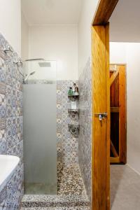 baño con ducha y puerta de madera en Lovely Loft Apartment in Kalibo, Aklan en Kalibo