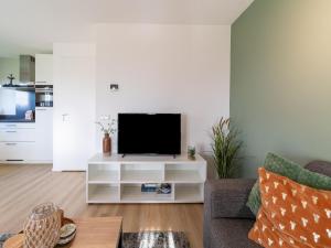 a living room with a television on a white entertainment center at Nice holiday home in Scherpenisse with terrace 