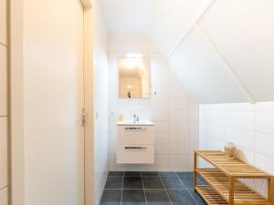 a bathroom with a sink and a mirror at Holiday Home in Scherpenisse near Nature Reserve in Westkerke +33 photos