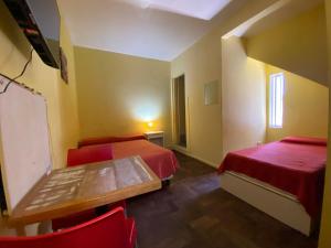 um quarto com duas camas e uma mesa e cadeiras em Mitre Suites em Buenos Aires