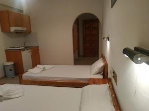 ein kleines Zimmer mit 2 Betten und einer Küche in der Unterkunft George Studios Stalida in Stalida