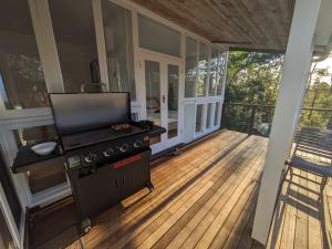 a screened in porch with a stove on a deck at Sanctuary Retreat in North Avoca