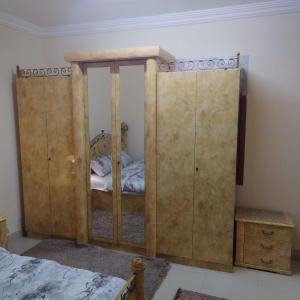 1 dormitorio con 1 cama y 2 armarios de madera en العين الهيلي مصباح بيت 9, en Al Ain