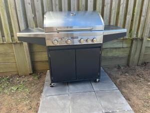 a grill sitting on a sidewalk next to a fence at Happy Haven at Eight Mile in Brisbane