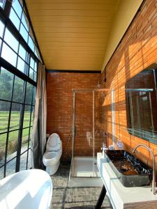 a bathroom with a toilet and a glass shower at The Maewin Coffee & Cottage Economy Family Room in Ban Huai Rin