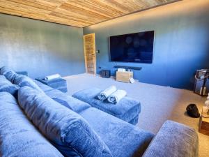 sala de estar con sofás azules y TV de pantalla plana en Chalet Notre-Dame-de-Bellecombe, 9 pièces, 11 personnes - FR-1-505-201 en Notre-Dame-de-Bellecombe