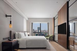 Voodi või voodid majutusasutuse New World Guangzhou Hotel toas