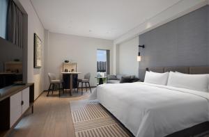 Voodi või voodid majutusasutuse New World Guangzhou Hotel toas