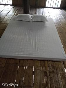 a bed sitting on top of a wooden floor at Puluonghomestay2 in Làng Cào