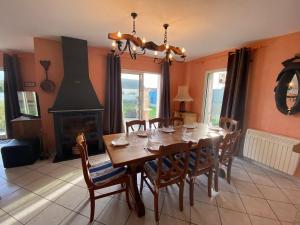 uma sala de jantar com uma mesa e uma lareira em Pretty Holiday Home, Treffiagat em Tréffiagat