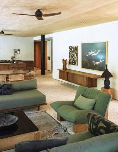 een woonkamer met groene meubels en een houten plafond bij Sandhouse Berawa in Canggu