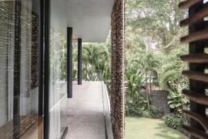 een gang van een huis met uitzicht op een tuin bij Sandhouse Berawa in Canggu