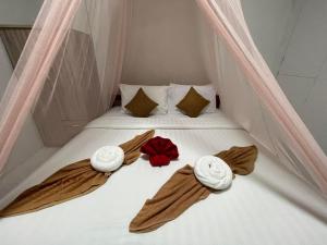 - un lit dans une tente avec des serviettes et des fleurs dans l'établissement Happy Home Kohjum, à Ko Jum