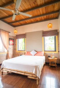 a bedroom with a large bed and two windows at Lagom Home in Hue