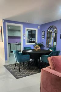 a dining room with a black table and blue chairs at Dreamhouse in Melbourne