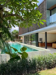 een extern uitzicht op een huis met een zwembad bij Sandhouse Berawa in Canggu