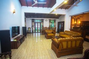 a living room with couches and a flat screen tv at Relax Villa In Koggala in Habaraduwa