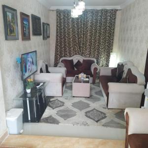 una gran sala de estar con sofás y una mesa. en العين الهيلي مصباح بيت 9, en Al Ain