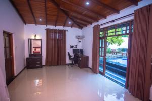 een woonkamer met een bureau en een spiegel bij Relax Villa In Koggala in Habaraduwa Central