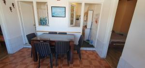 comedor con mesa, sillas y cama en Cabaña Quintero, en Quintero