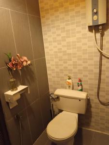 een badkamer met een toilet en een douche bij Pondok Keladi Langkawi Guesthouse in Pantai Cenang