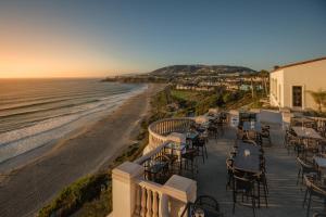 um restaurante com mesas e cadeiras na praia em The Ritz-Carlton, Laguna Niguel em Dana Point