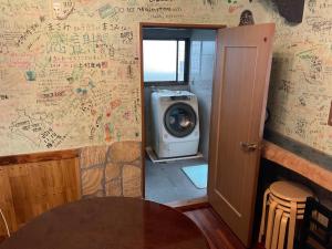 ein Zimmer mit einer Waschmaschine an der Wand in der Unterkunft ゆーみー. in Meinohama