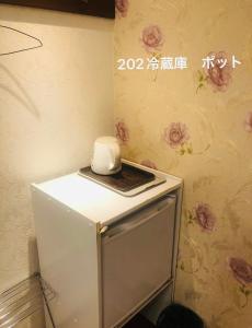 un piccolo frigorifero con sopra un oggetto bianco di 冠京ホテル a Tokyo
