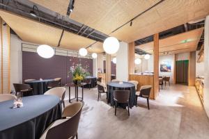 a dining room with tables and chairs and lights at Atour S Hotel Beijing Guomao CBD - FunsCenter in Beijing
