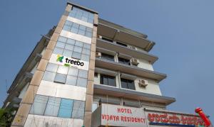 马尼帕尔Itsy Hotels Vijaya Residency的上面有酒店标志的高楼